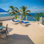 Blue Loungers on Beige Balcony Beside Sea Landscape Photography