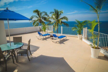 Blue Loungers on Beige Balcony Beside Sea Landscape Photography